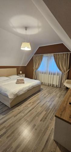 a bedroom with a bed and a large window at Forest Grill in Piatra Neamţ