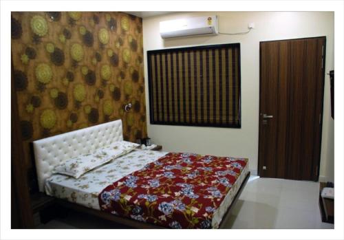 a bedroom with a bed with a floral bedspread at Matoshri Homestay Airport Road in Nagpur