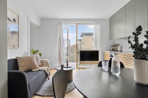 a living room with a table and a couch at Modern & Stylish Apartment with Private Balcony in Aarhus