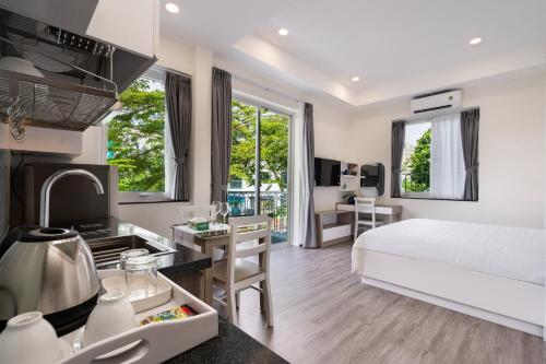 a hotel room with a bed and a kitchen and a room at F-APARTMENT in Ho Chi Minh City
