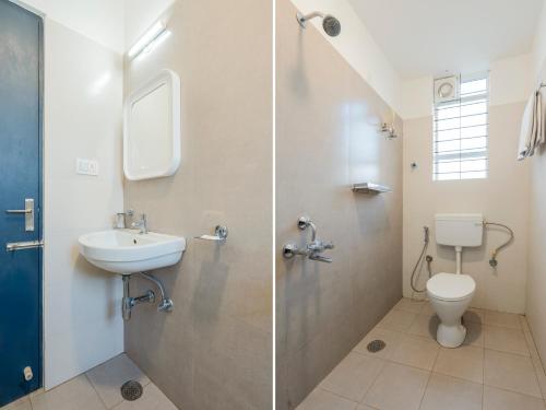 a bathroom with a toilet and a sink at Hotel Royal Manyata in Bangalore