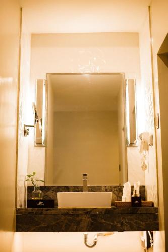 a bathroom with a sink and a large mirror at Waterworld Hotel Cebu in Mandaue City
