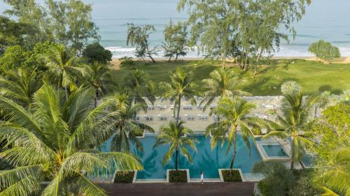 an aerial view of a resort with palm trees and the ocean at Anantara Mai Khao Phuket Villas in Mai Khao Beach