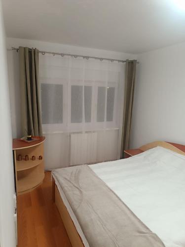 a bedroom with a white bed and a window at Apart Robert 1 in Bicaz