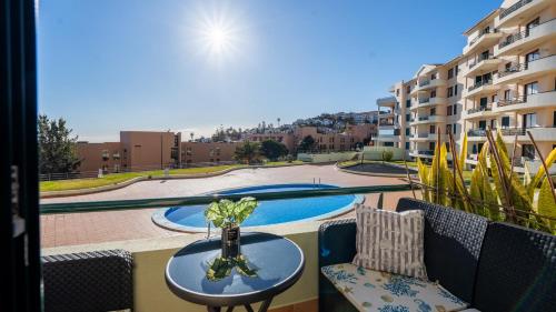 a balcony with a table and chairs and a swimming pool at The Seaview Studio by LovelyStay in Caniço