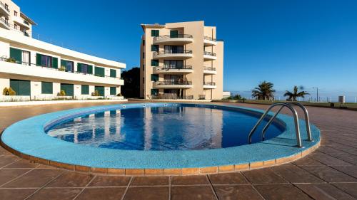 a swimming pool in front of a building at The Seaview Studio by LovelyStay in Caniço