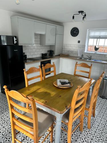 a kitchen with a wooden dining table and chairs at 3 bed bungalow Penrhyn Bay Llandudno in Llandrillo-yn-Rhôs