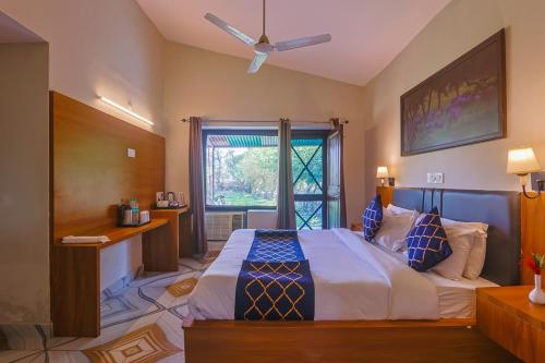 a bedroom with a large bed and a window at Tripp Jim Corbett A River Access Resort in Marchula