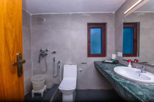 a bathroom with a toilet and a sink at Tripp Jim Corbett A River Access Resort in Marchula
