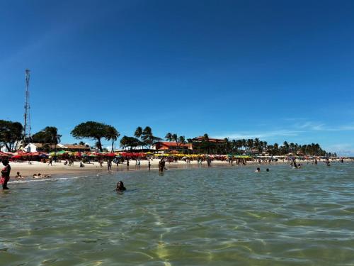 a group of people in the water at a beach at Sol, mar, equilíbrio perfeito praia do frances! in Marechal Deodoro