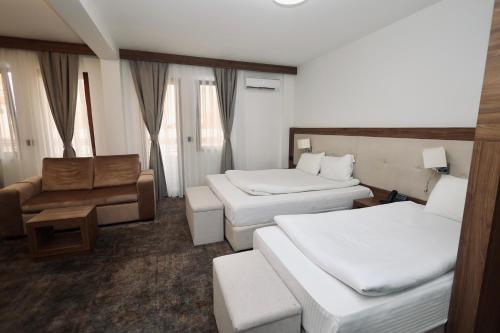 a hotel room with two beds and a couch at Aqua Spa Lux in Novi Pazar