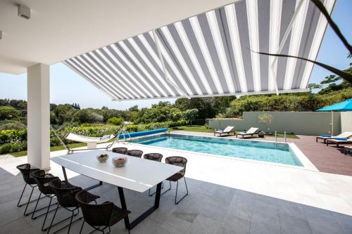 a patio with a white table and chairs and a pool at Villa Soderini in Dubrovnik