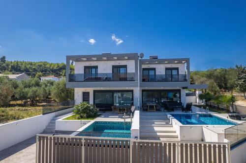 a villa with a swimming pool and a house at LUKA VILLAS Plage in Polychrono