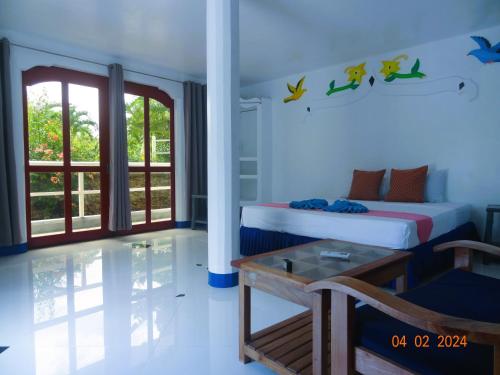 a bedroom with two beds and a table in it at MG CHATEAU RESORT Grand Suites in Nacpan