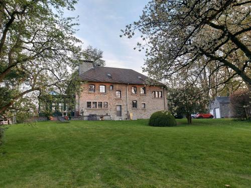 a large brick house with a large yard at Au Clos Caleste in Wellin