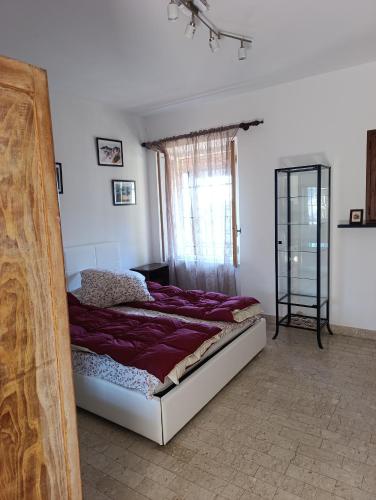 a bedroom with a bed with purple sheets and a window at La Panciotta in Azzano