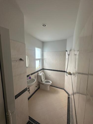 a bathroom with a toilet and a sink at HulaFling Homestay in Ban Bo Han