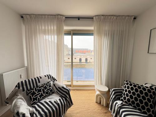 a living room with a couch and a large window at Nuit D'or - Cape Champagne - Séjour & Pro in Épernay