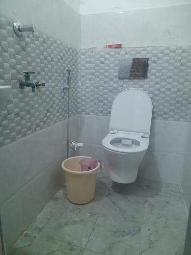 a bathroom with a white toilet and a bucket at BAGIYA Hut RESORT in Billi