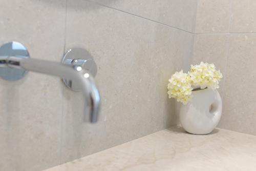 a vase of flowers sitting on a counter in a bathroom at Cohav Sea View in Eilat