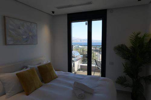 a bedroom with a bed with a view of a balcony at Cohav Sea View in Eilat