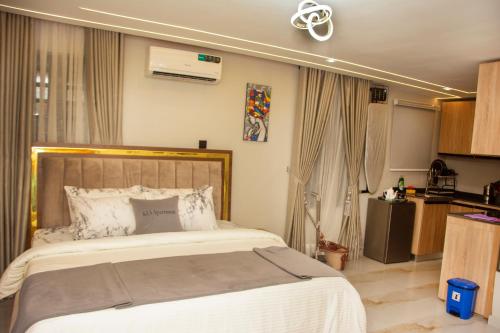 a bedroom with a large bed and a kitchen at KLSApartment in Lagos