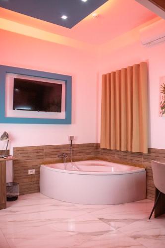a large bathroom with a tub and a tv at Augustea Travel Rooms in Frignano