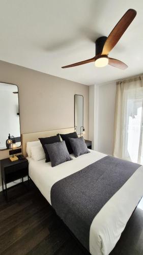 a bedroom with a large bed with a ceiling fan at Apartamentos Carmen del Turia in Valencia