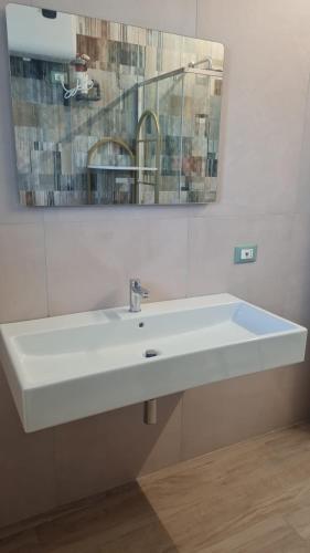 a bathroom with a white sink and a mirror at Civitas Locanda in Ghedi