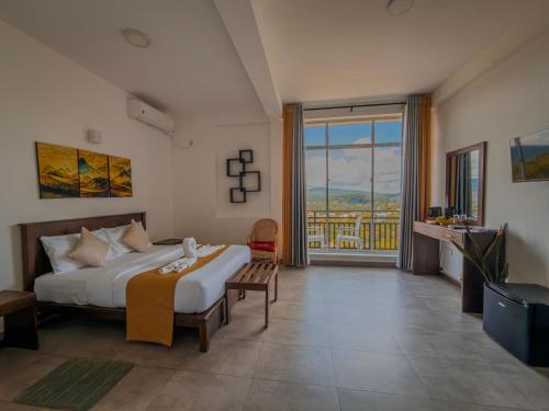 a bedroom with a large bed and a large window at Red Chillies Nature Inn in Kandy