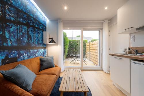 a living room with a couch and a table at Air Nomad • Sydney in Valenciennes