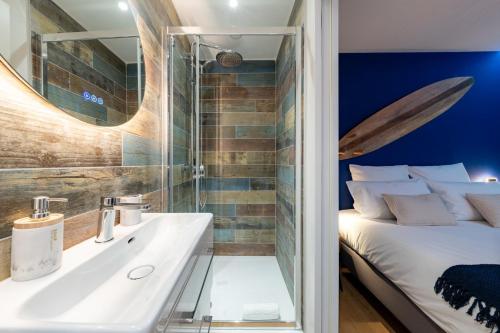 a bathroom with a sink and a bed at Air Nomad • Sydney in Valenciennes