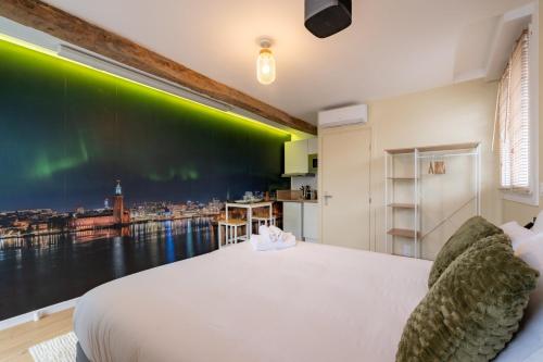 a bedroom with a large bed with a green wall at Air Nomad • Stockholm in Valenciennes