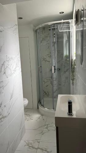 a white bathroom with a shower and a toilet at Central London Flat 2 bathrooms in London