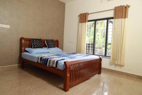 a bed in a room with a large window at Well maintained Calm atmosphere in Putuppalli