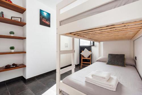 a small bedroom with a bunk bed and a staircase at Tramontana 28B by Escape Home in Fornells