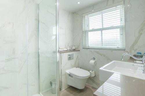 a bathroom with a shower and a toilet and a sink at Sidmouth Harbour Hotel & Spa in Sidmouth