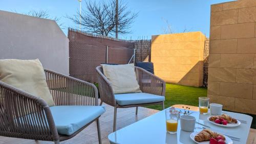a patio with two chairs and a table with food on it at ALLONBAY spa & beach house in Villajoyosa