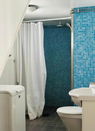 a bathroom with a white shower curtain and a toilet at Kiladalens Golf & Lodge in Nyköping