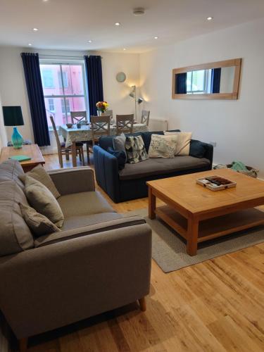 a living room with a couch and a coffee table at Stylish flat in central Tenby & free parking in Tenby