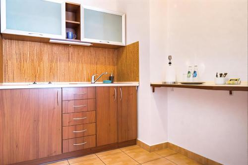 a kitchen with wooden cabinets and a sink at IK Apartamenty in Rzeszów