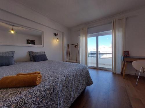 a bedroom with a bed and a view of the ocean at Praia Dona Ana - Bedrooms in shared apartment in Lagos