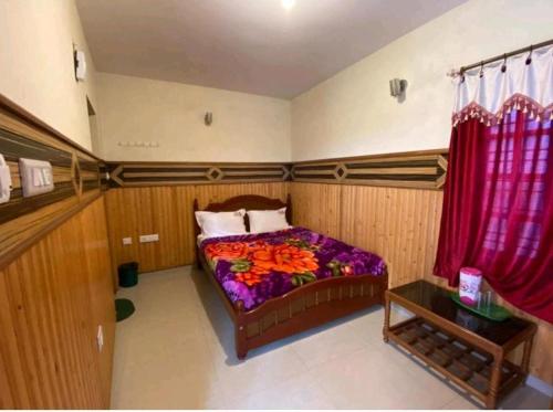 a bedroom with a bed and a red curtain at Padayappa Residency in Kodaikānāl