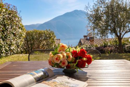 a bouquet of flowers sitting on a table with a book at Apartment Maya - Tremezzina in Tremezzo