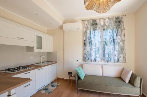 a kitchen with a couch in front of a window at Gioia apartment in Sabaudia