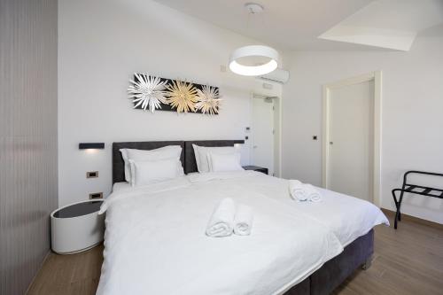a bedroom with a large white bed with slippers on it at Hotel - Teranea City Hvar in Hvar