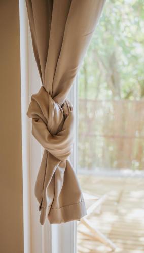 a curtain that is tied up in a window at Naest - Authentic Escapes Grand House in Nijmegen