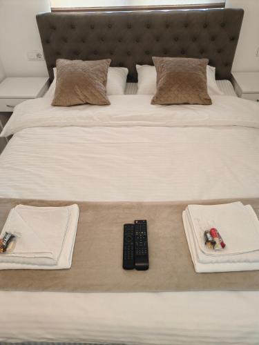 a bed with two plates and a remote control on it at Apartmani B&R in Lazarevac