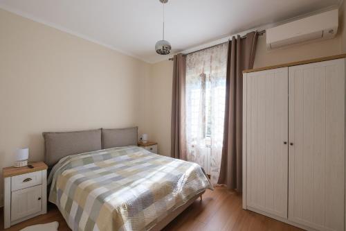 a bedroom with a bed and a large window at Gioia apartment in Sabaudia