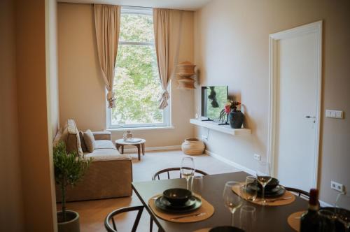 a living room with a table and a window at Naest - Authentic Escapes Grand House in Nijmegen